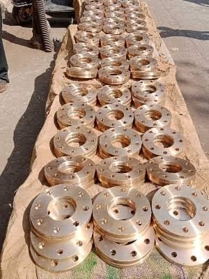 Rows of finished bronze and gunmetal flanges laid out for inspection at Sunflex Metalloy, flanges manufacturer Gujarat India